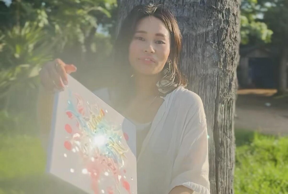 木のそばで夢吹アートを手にするkana