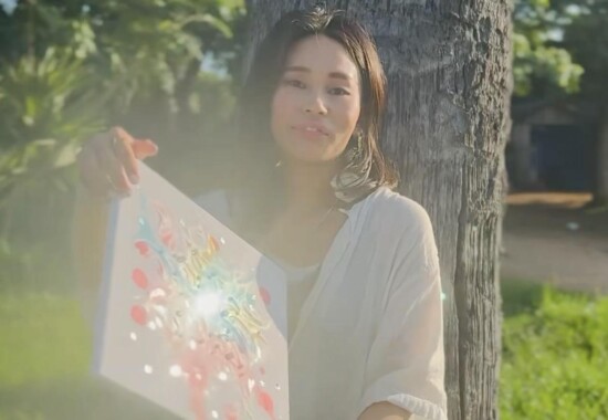 木のそばで夢吹アートを手にするkana